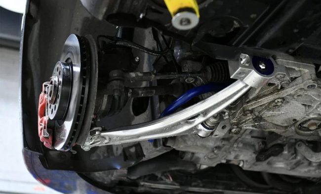 O braço oscilante, também chamado de braço de controle ou bandeja de suspensão, é um componente metálico em forma de triângulo que liga as rodas do veículo ao chassi ou monobloco. Ele permite que as rodas se movimentem para cima e para baixo de forma independente e suave, absorvendo os impactos e irregularidades do solo. Além disso, ele mantém as rodas alinhadas com o corpo do carro, facilitando a direção e o controle do veículo.